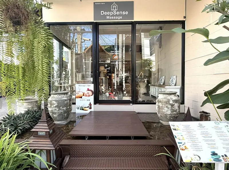 The DeepSense Massage shop front with plants, stone jars and the menu board