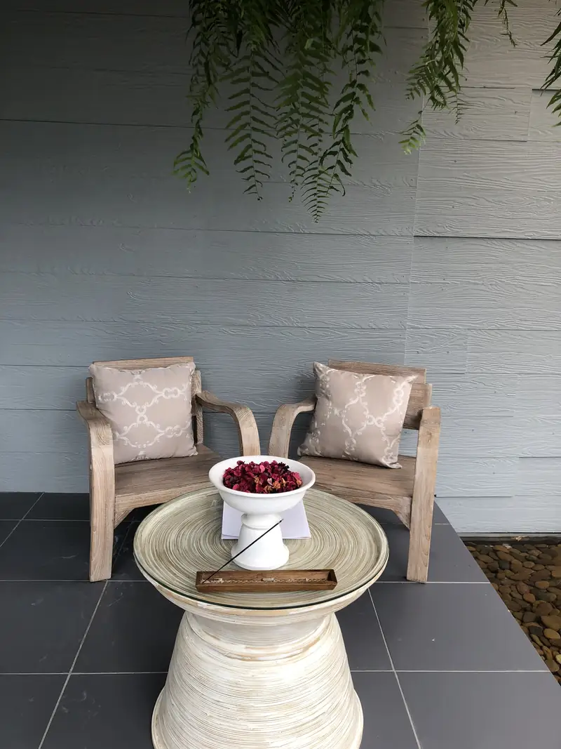 Two wooden armchairs and a bowl of rose petals on the front terrace